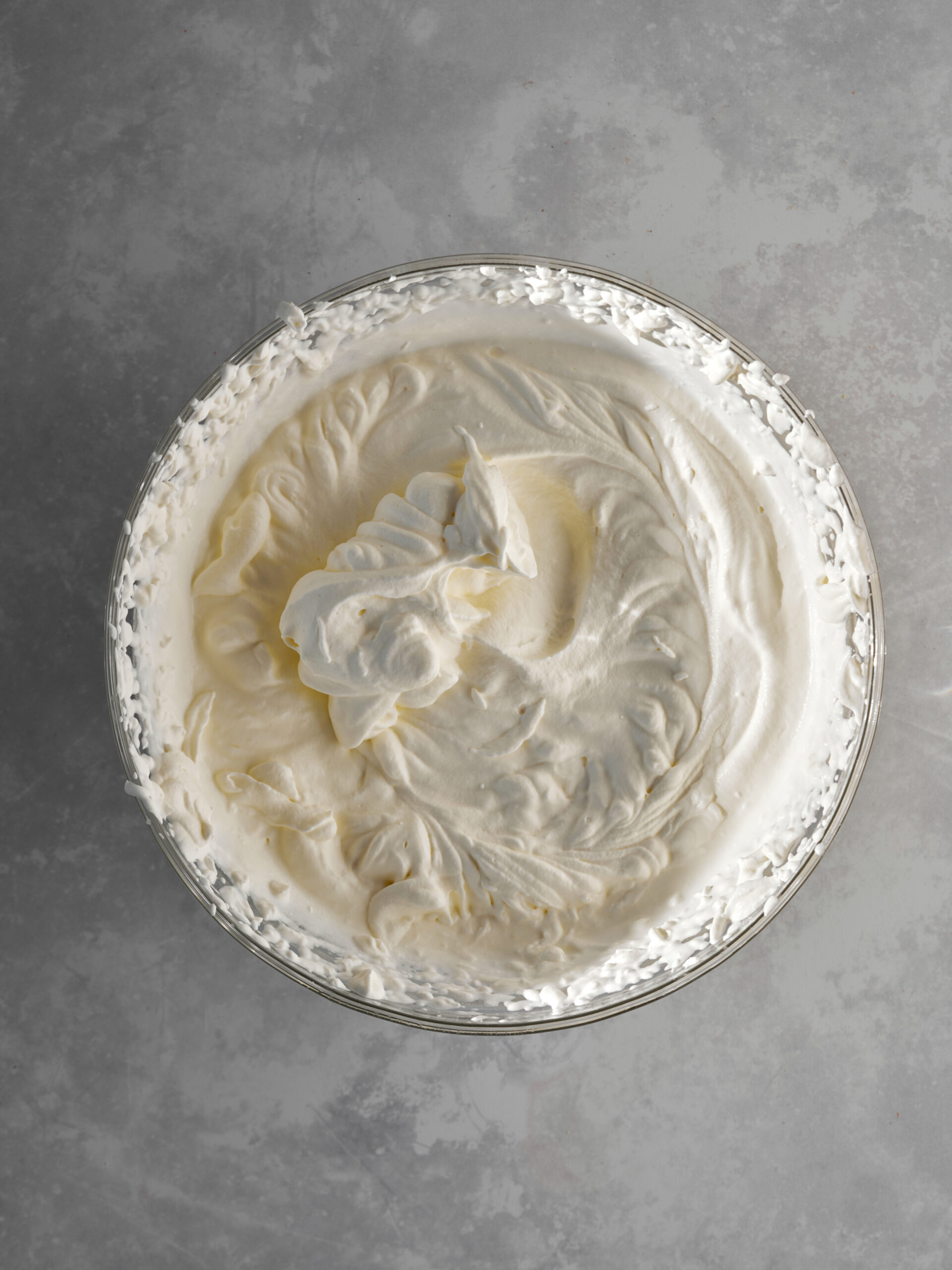 Whipped cream in a large glass bowl.