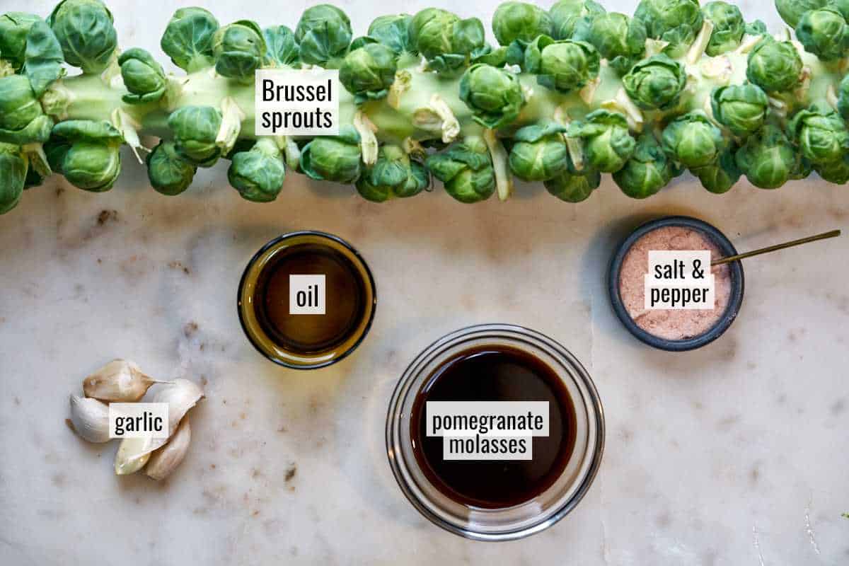 Brussel sprouts and other ingredients on a marble countertop.