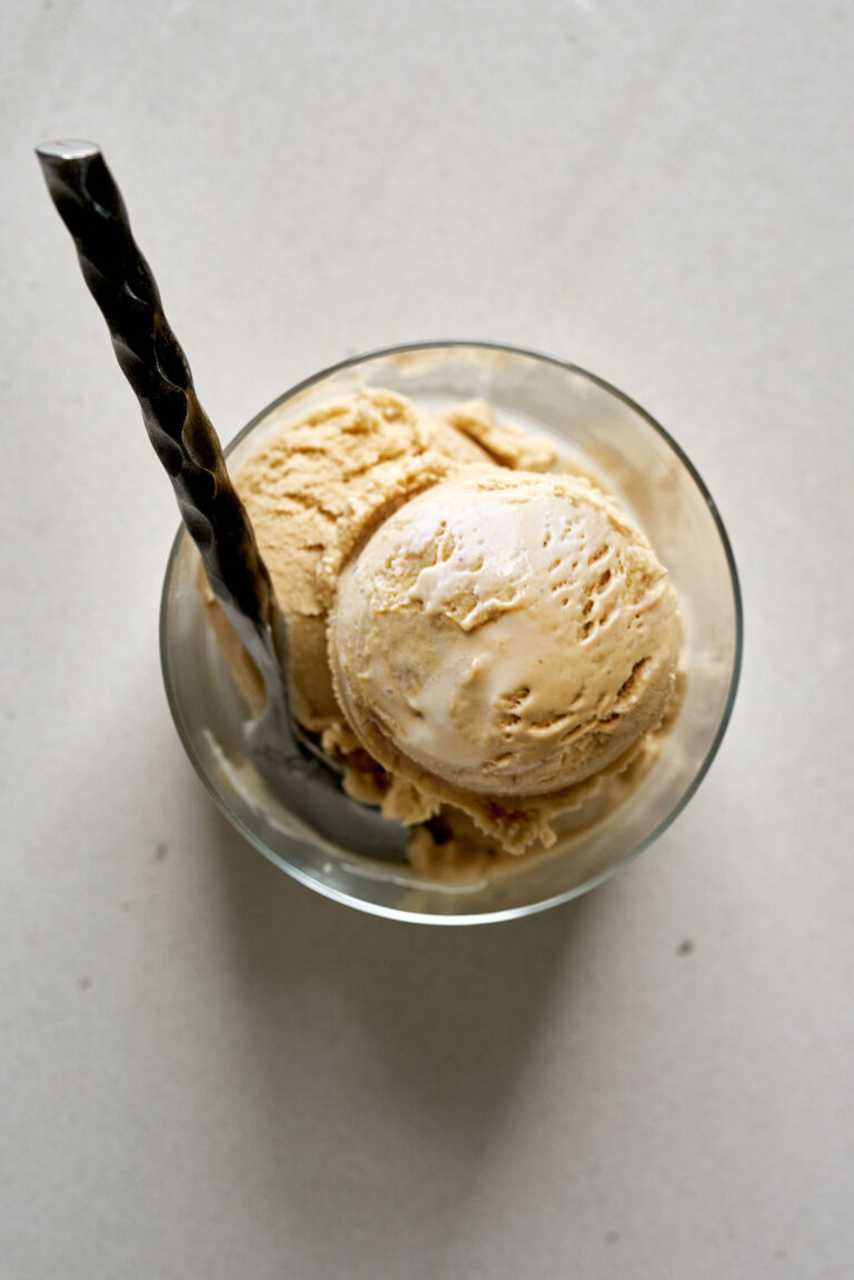 Ice cream in a glass cup with a spoon.