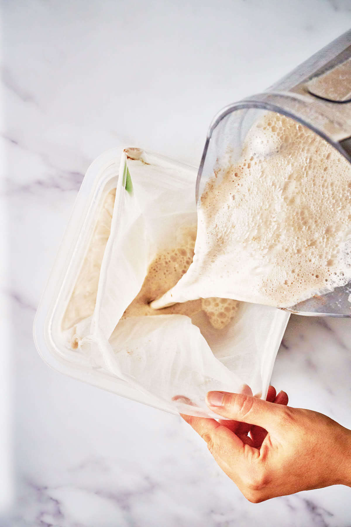 Pouring frothy milk into a bag.