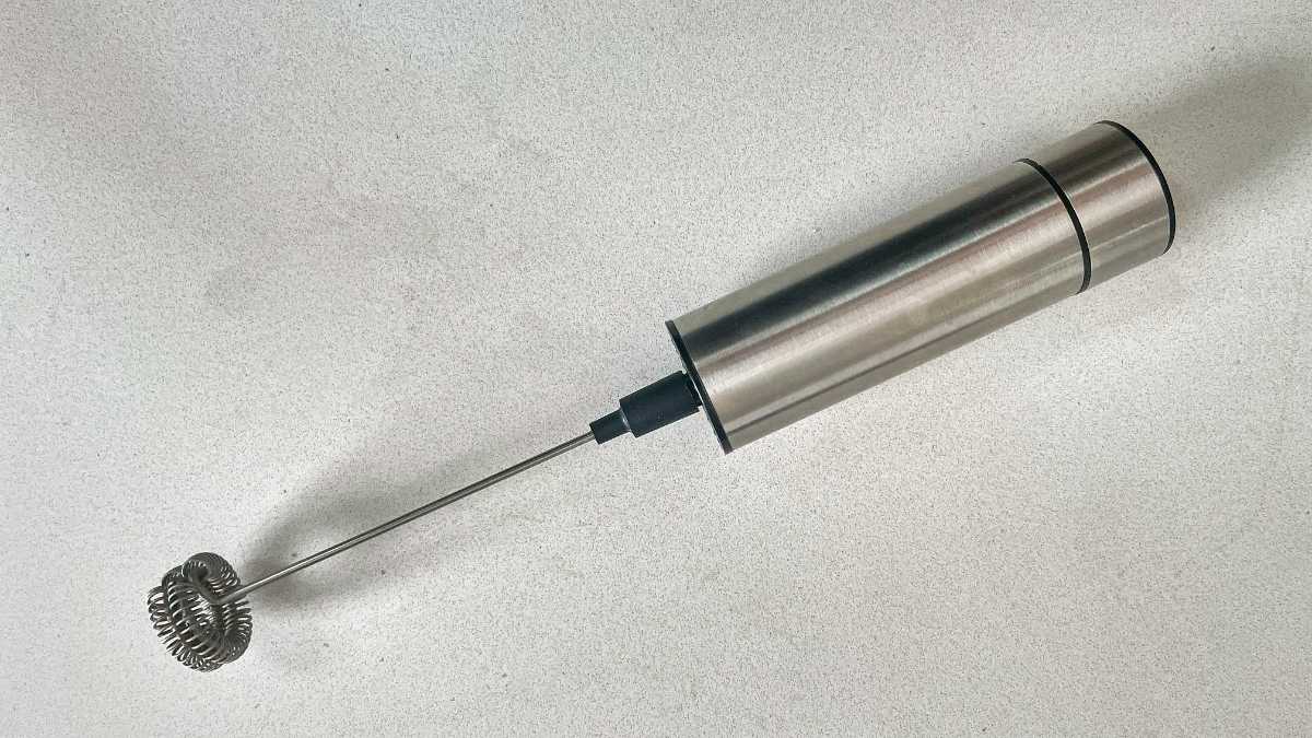 A silver electric frother on a countertop.