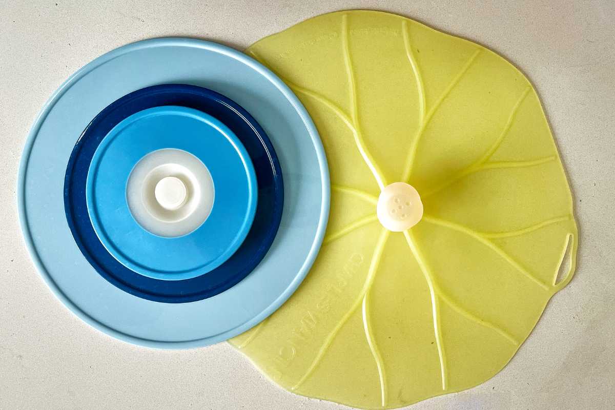 One blue and one green silicone bowl lids on a white countertop.