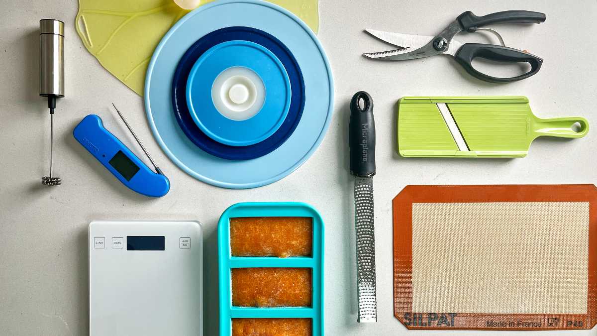 Flat lay of multiple kitchen tools on a white countertop.