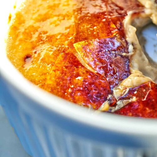 Close up inside a ramekin filled with cracked sugar and creme brulee.