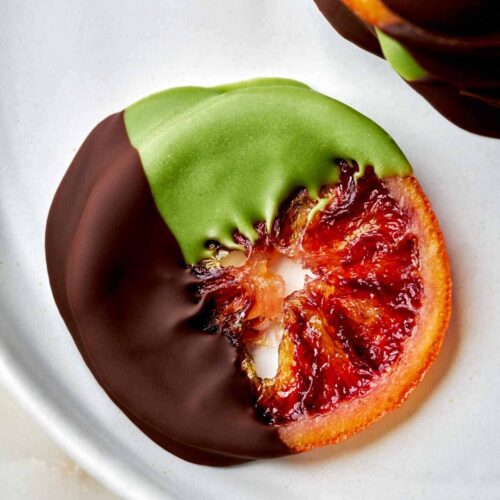 Orange slices dipped in chocolate and green chocolate.