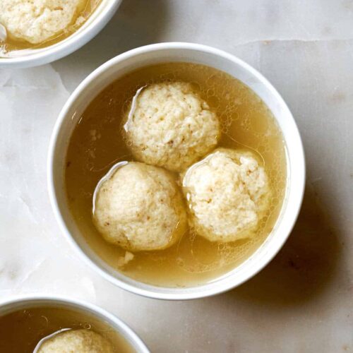 Three bowls of matzo ball soup.