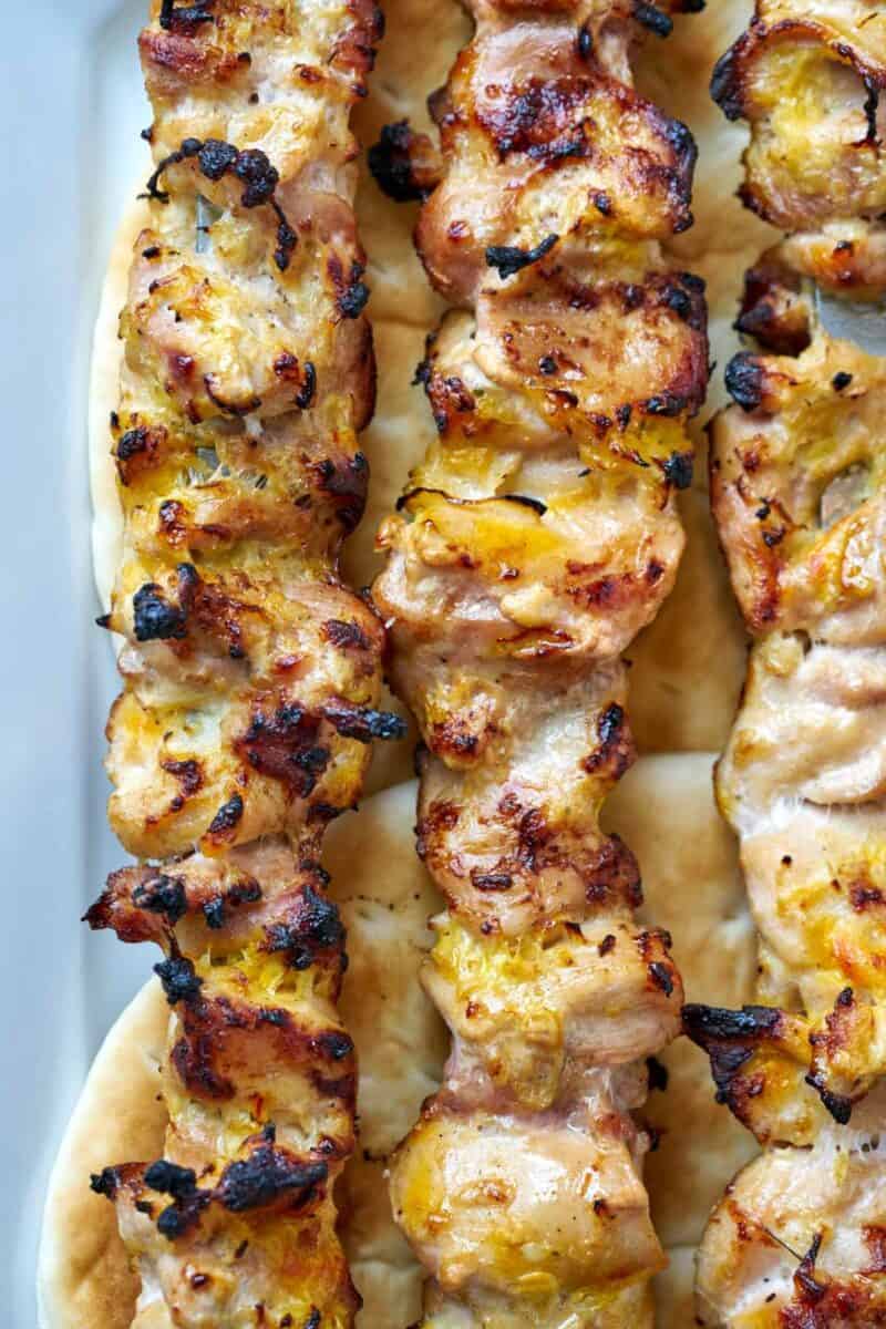 Three rows of chicken kabobs.