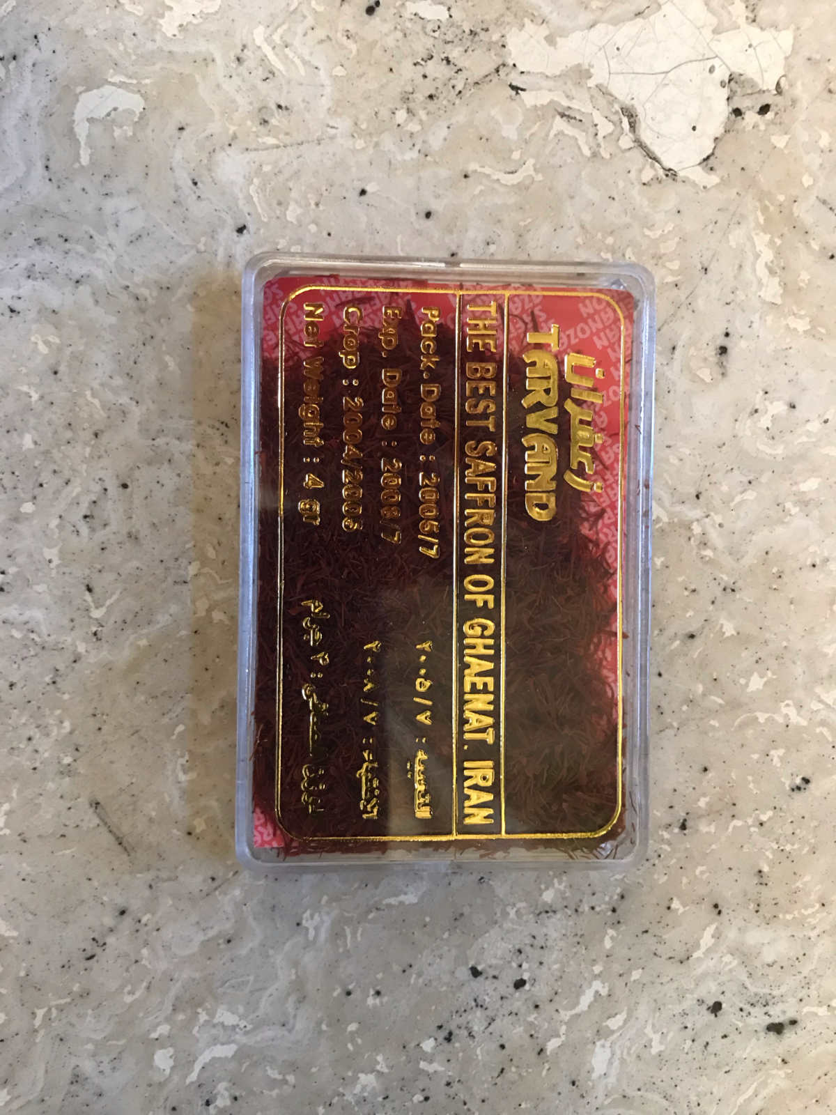 Saffron in a plastic container with gold writing.