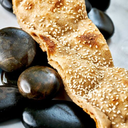 Strip of flatbread laying over rocks.