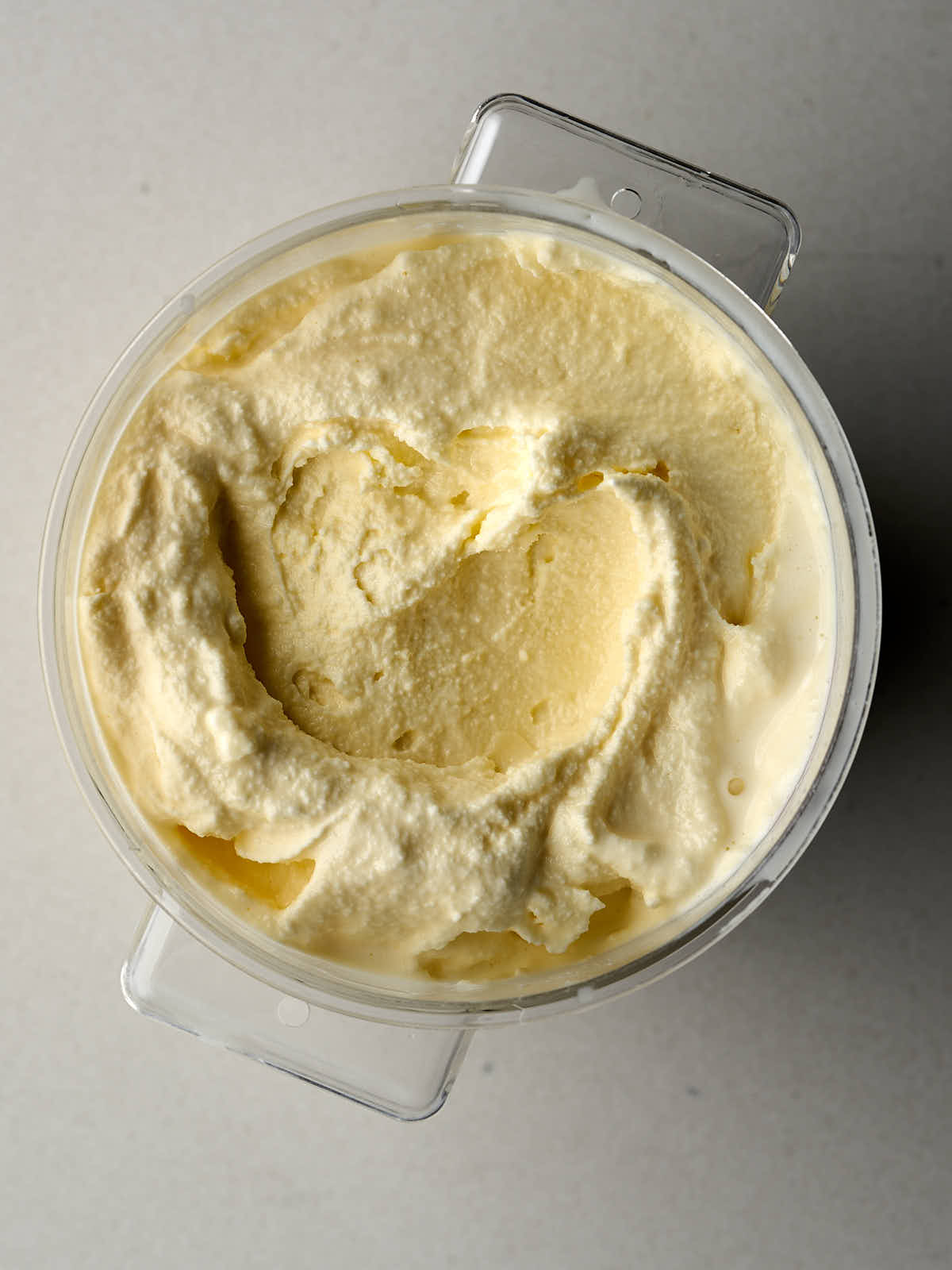 Yellow ice cream in a clear container.