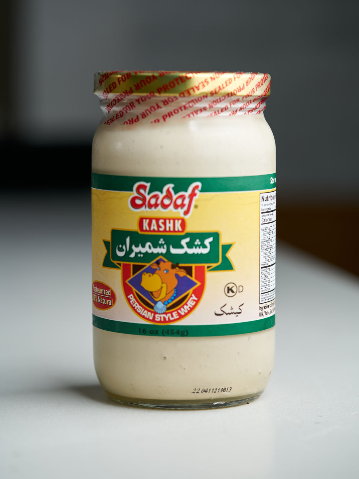 Jar of beige liquid with sheep on the label.