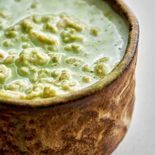 Green runny oatmeal in a matcha bowl.