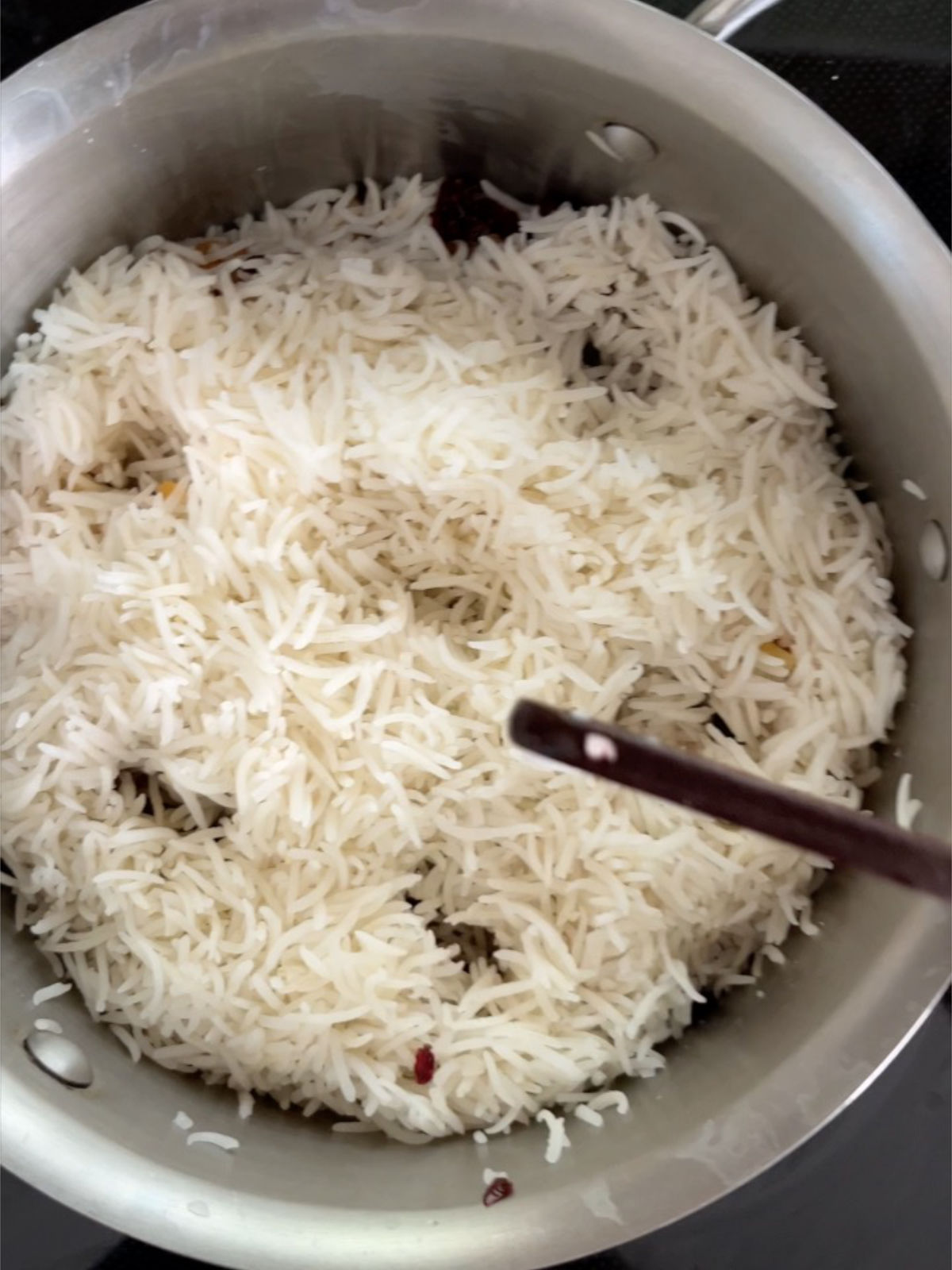 Rice in a pot with six holes in the pile of rice.