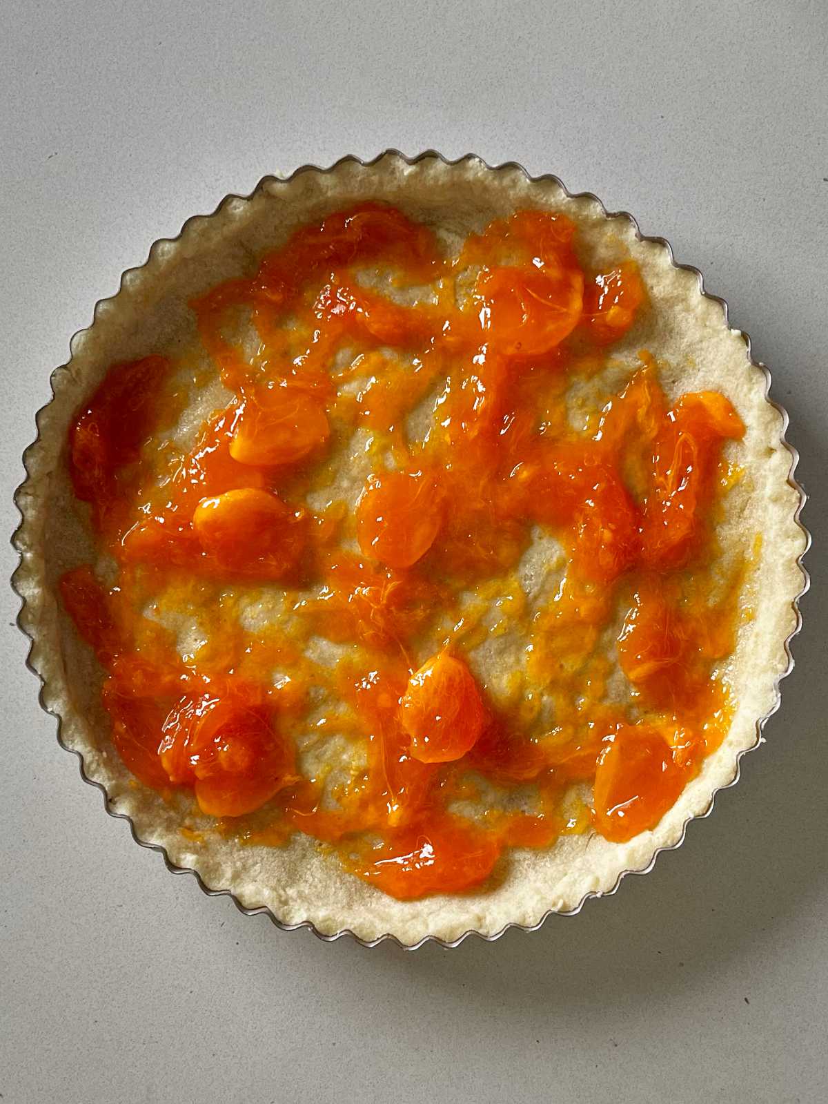 Orange puree spread around a blind baked tart shell.