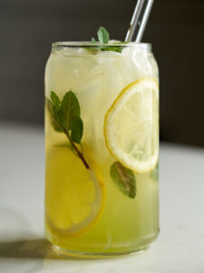 Lemonade in a soda can glass with lemon slices and fresh mint.
