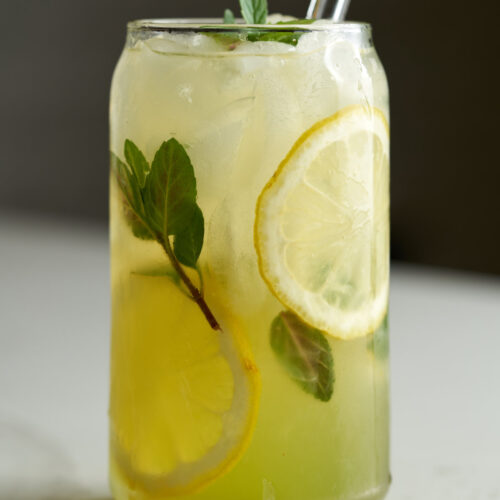 Lemonade in a soda can glass with lemon slices and fresh mint.