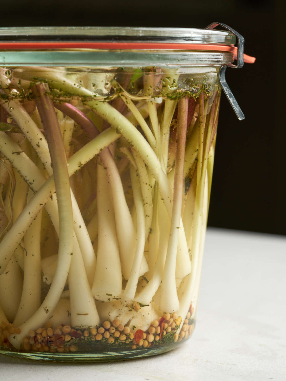 Side view of white ramp bulbs in a clear liquid in a sealed glass jar