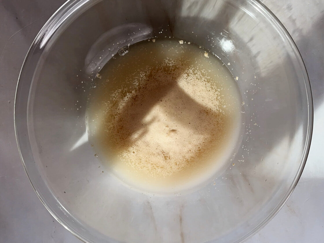 Foaming yeast in a glass bowl with sunlight.