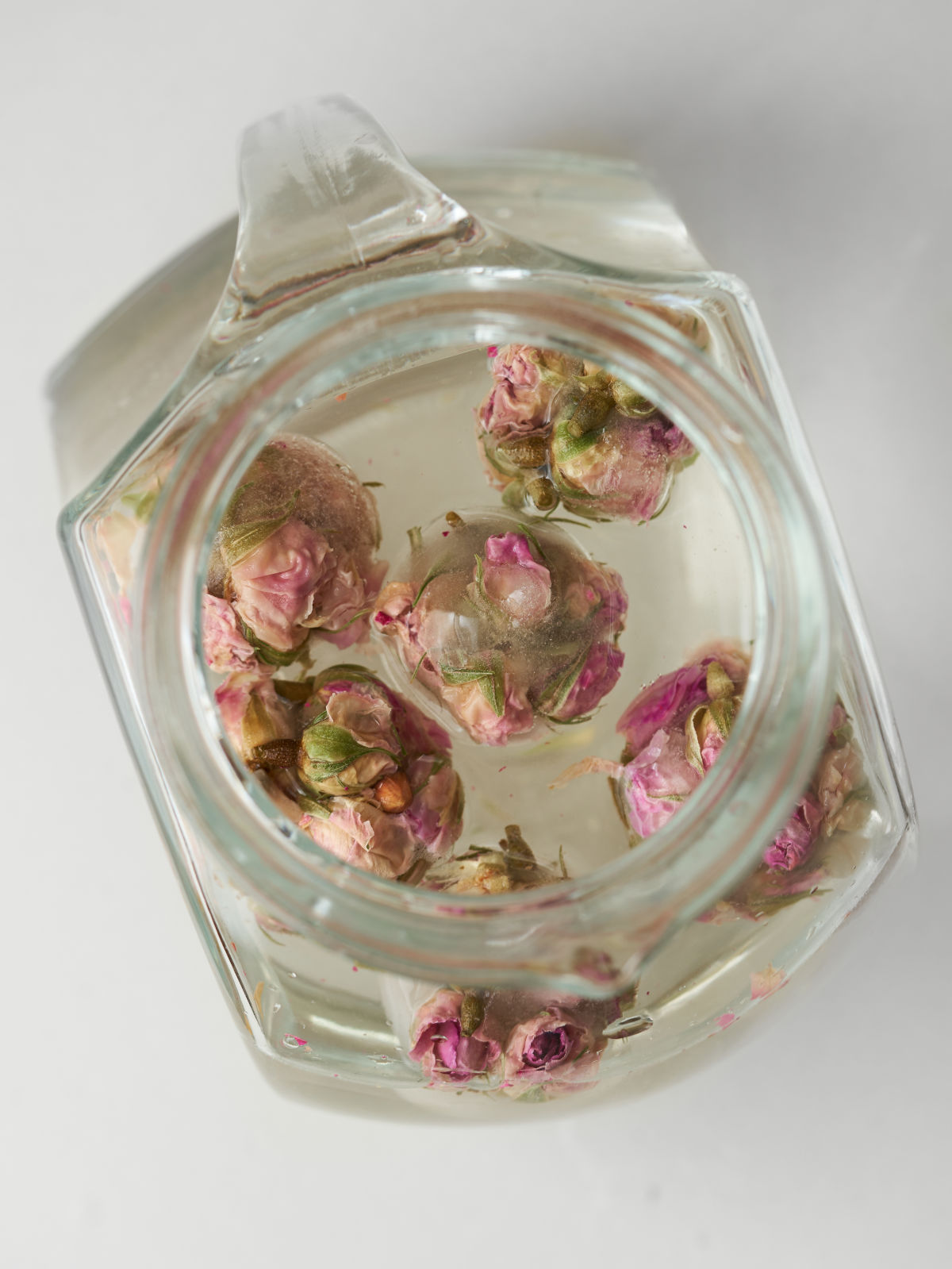 Rose bud ice cubes in a pitcher of water.