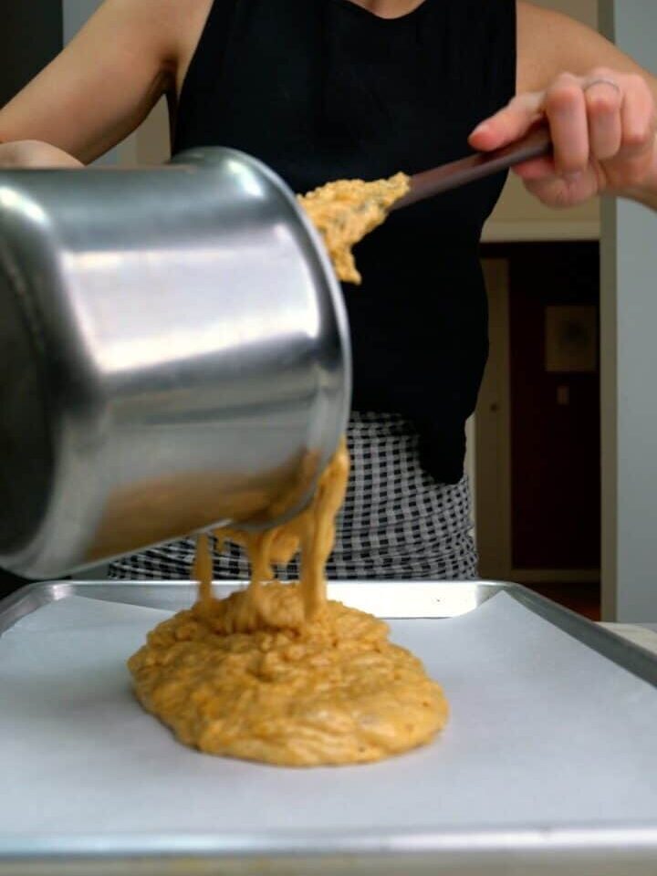 Pouring toffee on a baking sheet.