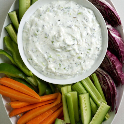 Yogurt dip on a platter of raw veggies.