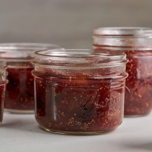 Small glass jars filled with red fig jam.