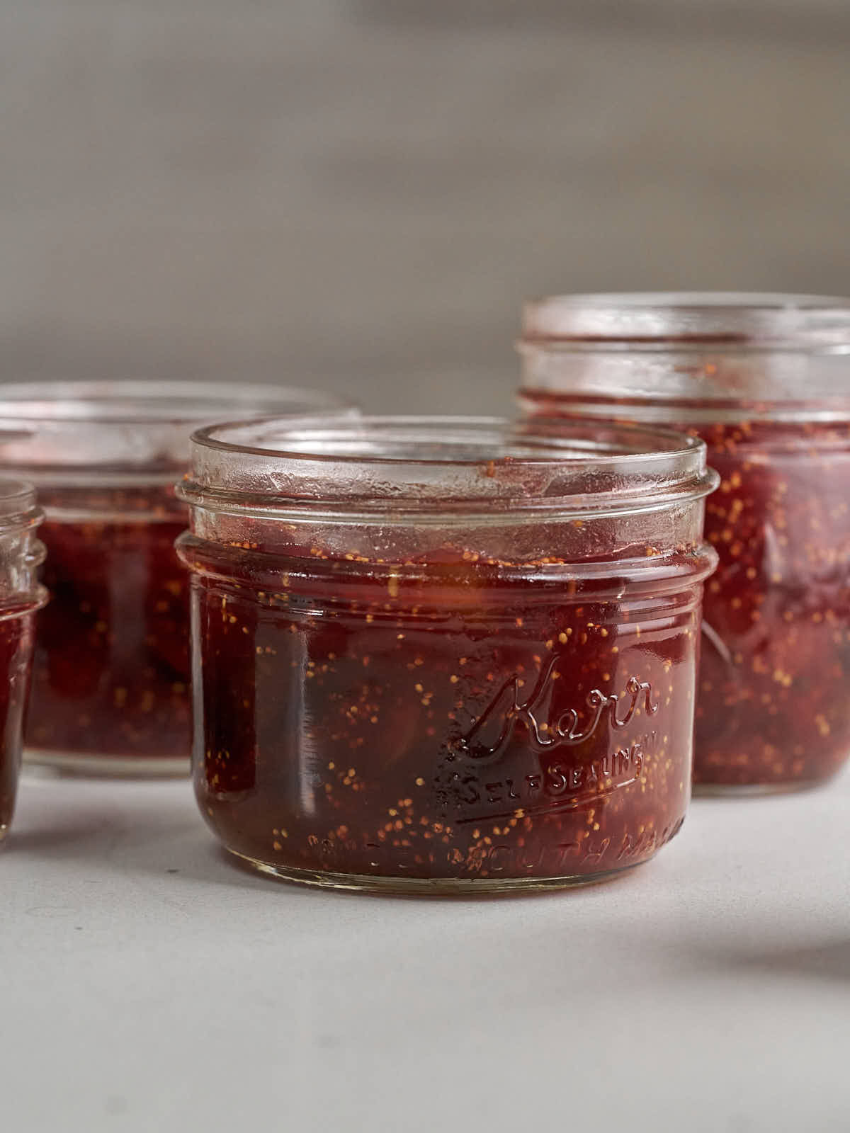 Glass jars filled with red fig jam.