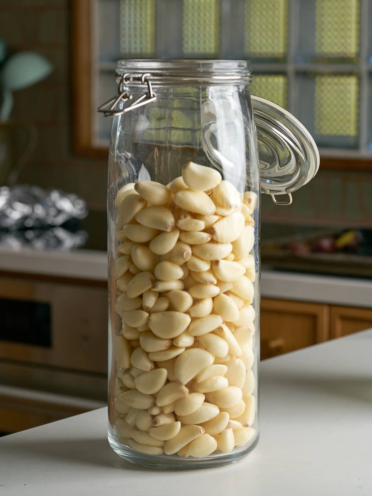 Glass jar filled with peeled garlic cloves.