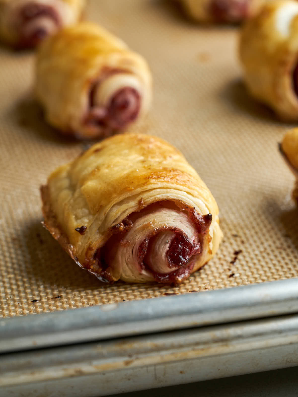 Flaky pastry roll on a baking sheet.