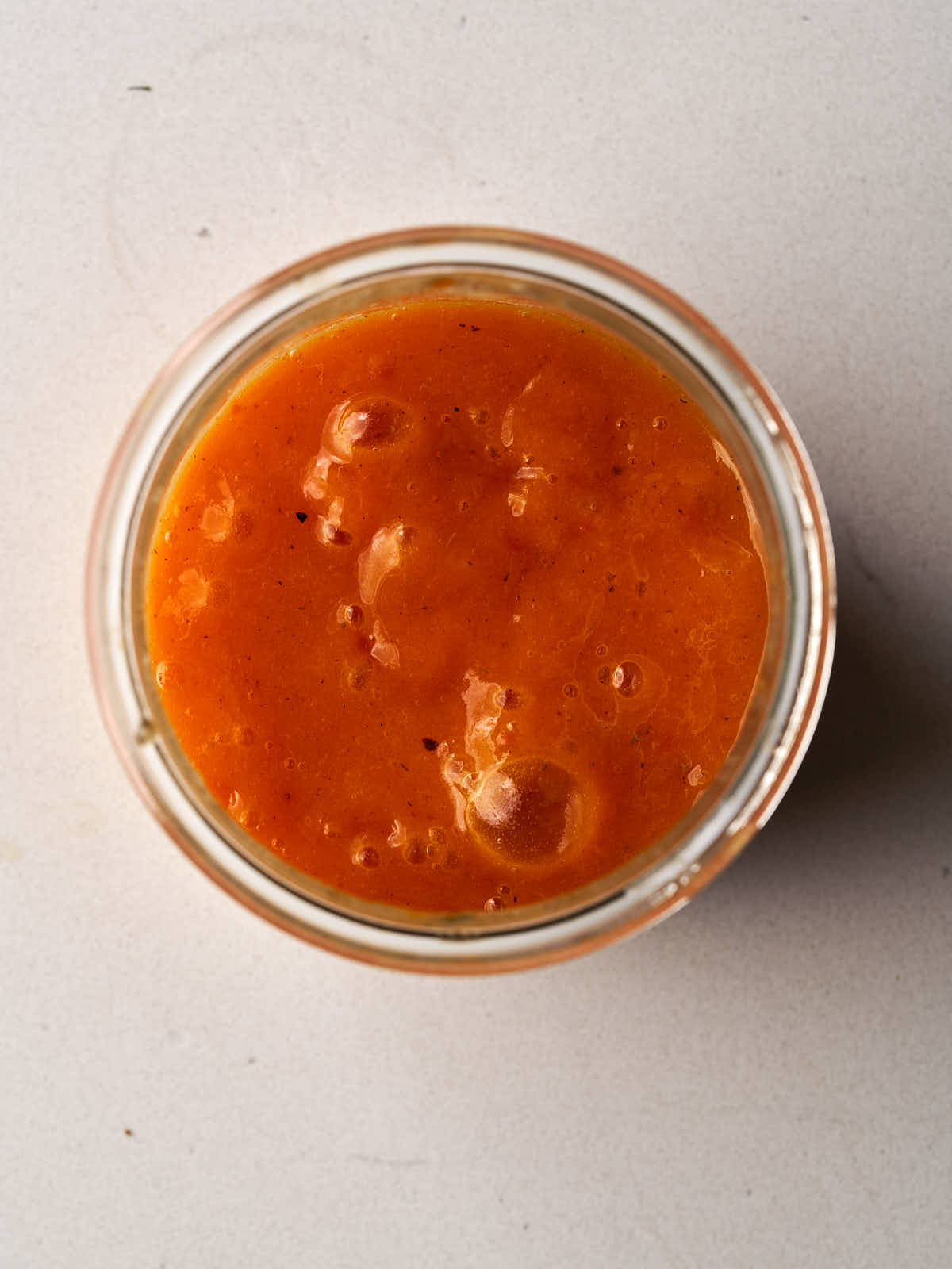 Orange persimmon puree in a glass bowl.