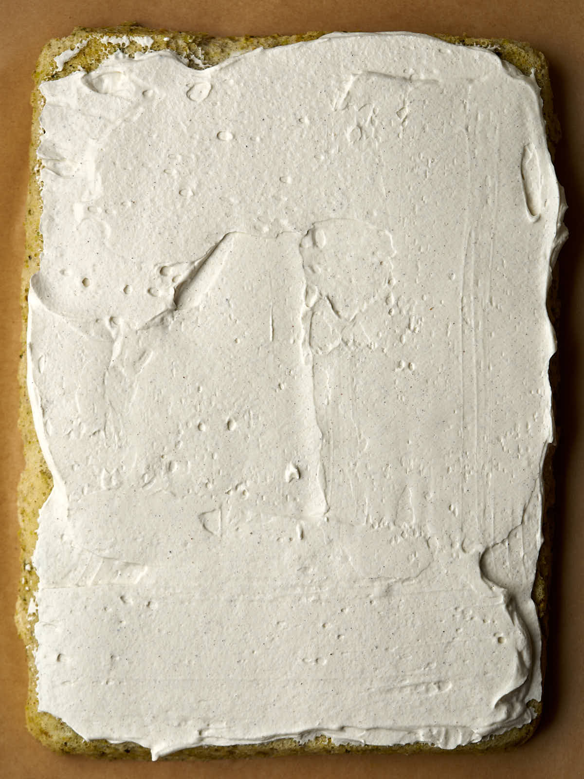 Rectangular cake with a thin layer of whipped cream.