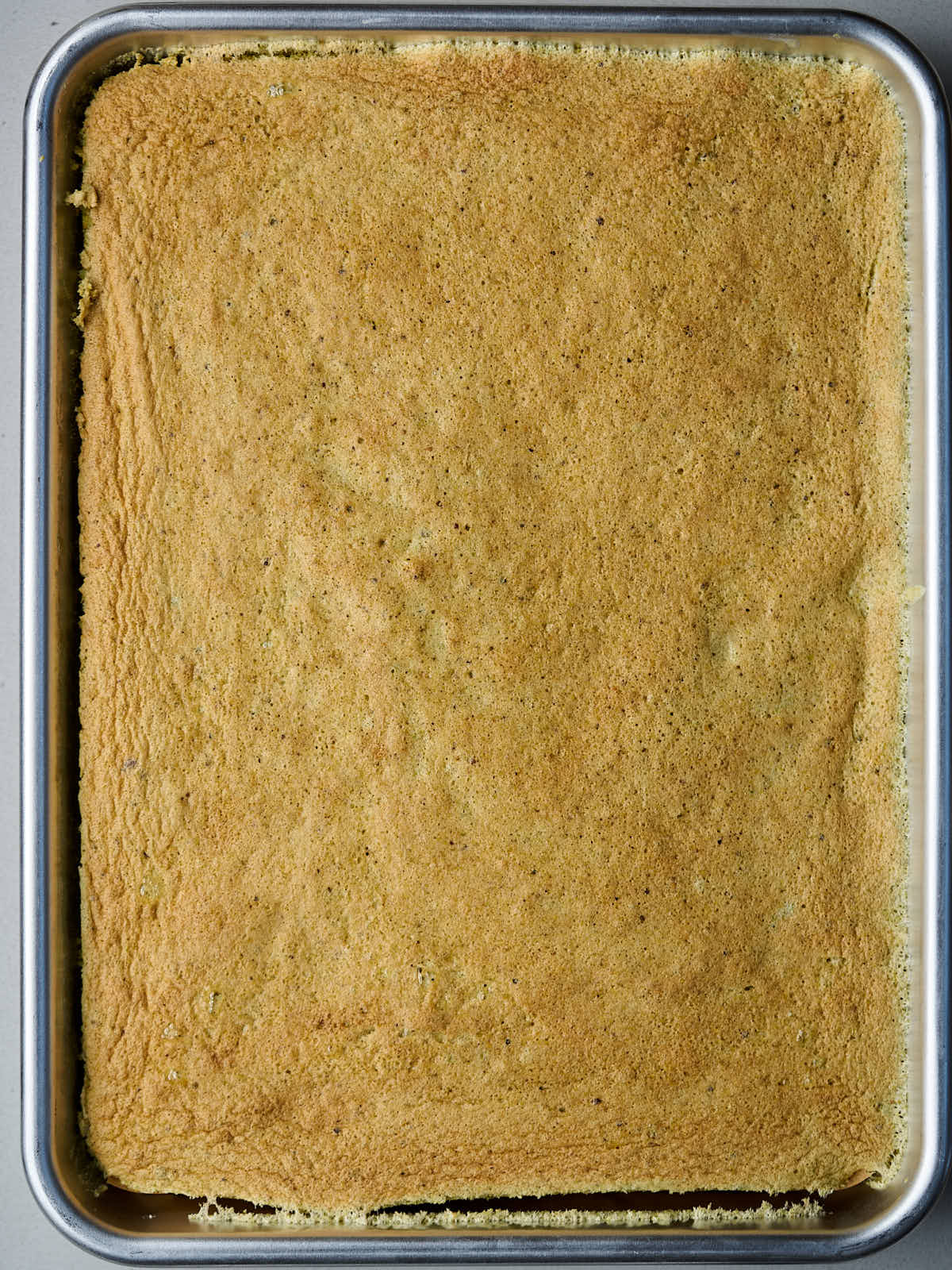 Browned cake in a quarter sheet pan.