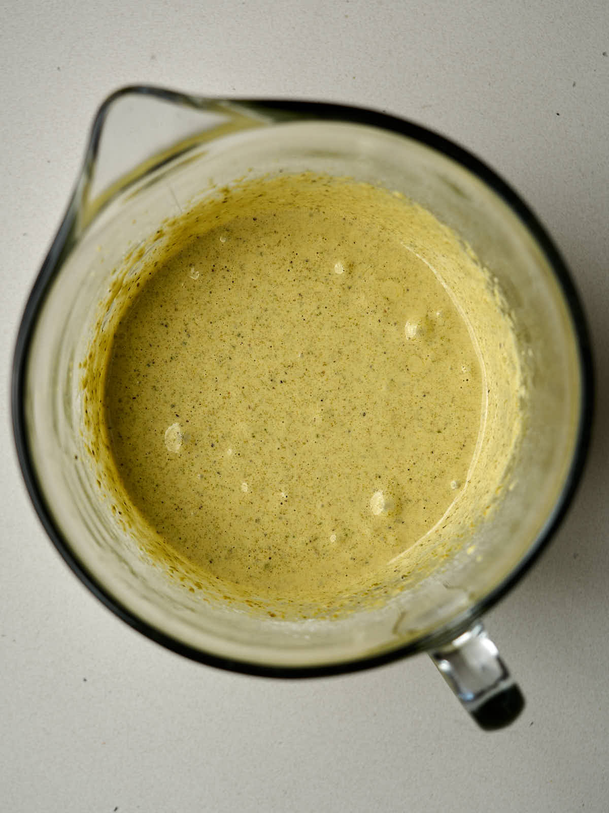 Pale green batter in a glass mixing bowl.