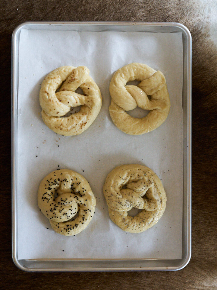 Boiled pretzels on a metal baking sheet. with parchment paper.