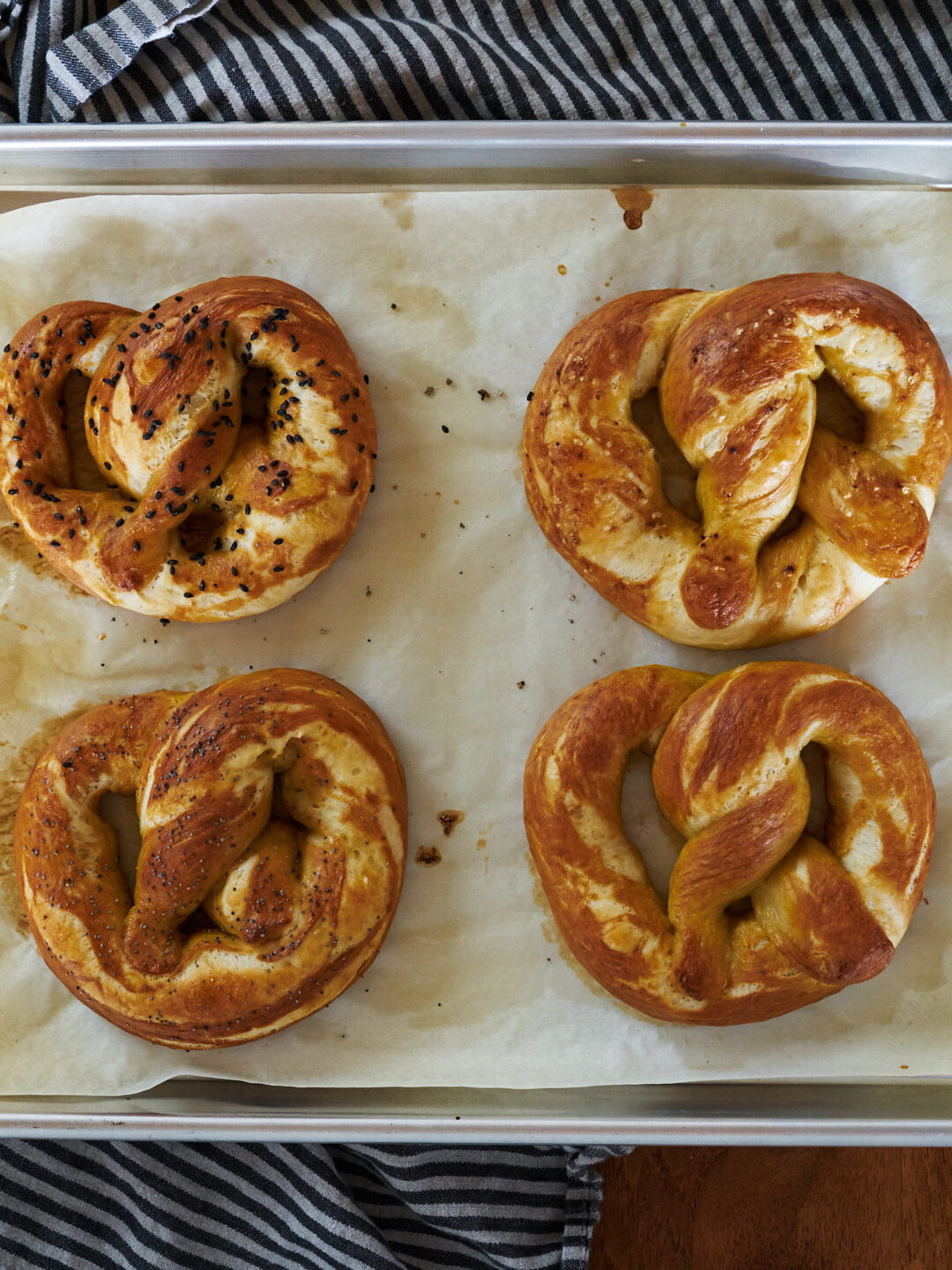 Cooked brown pretzels on a baking sheet.