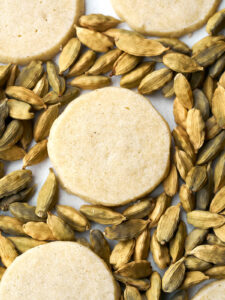 Shortbread cookies on a bed of cardamom pods.