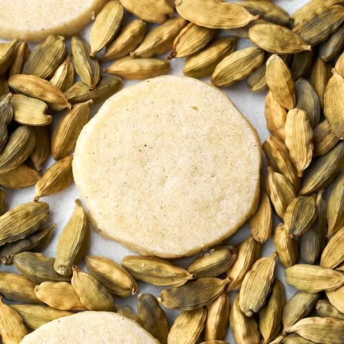 Shortbread cookies on a bed of cardamom pods.