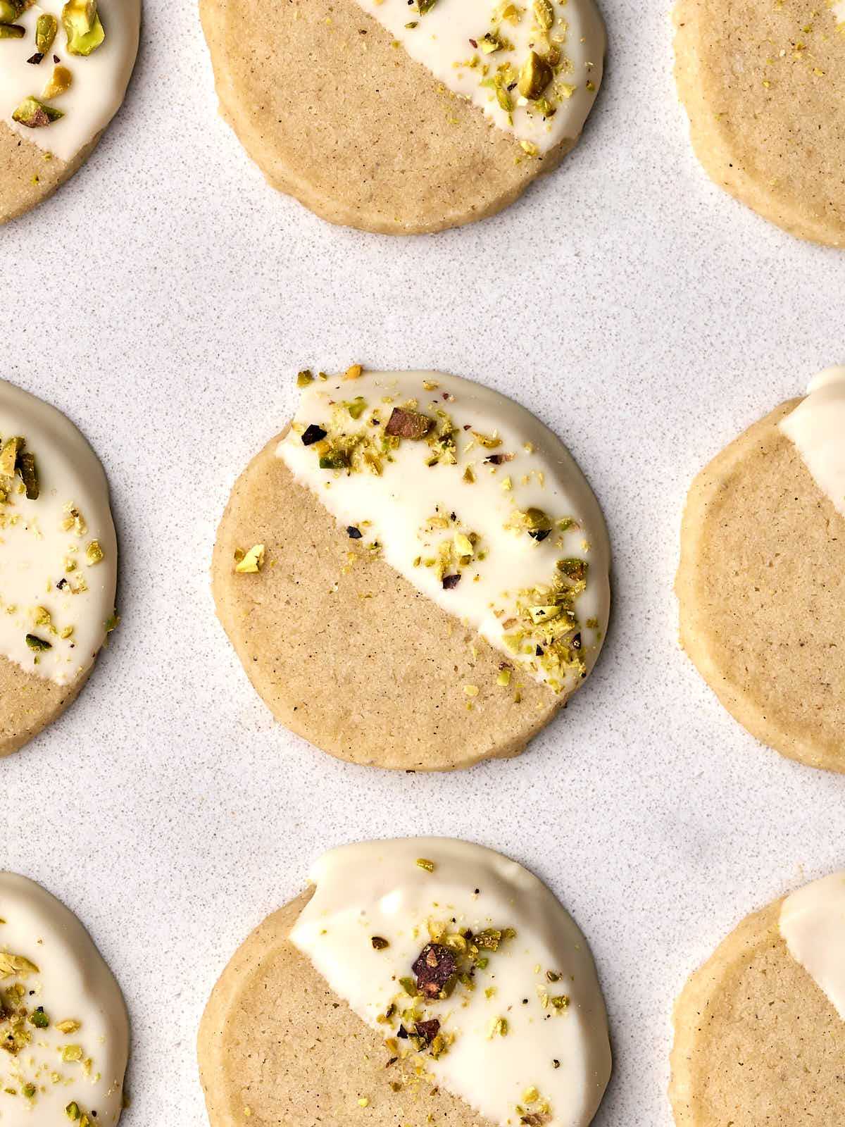 Shortbread cookies dipped in white chocolate and sprinkled with chopped pistachios.