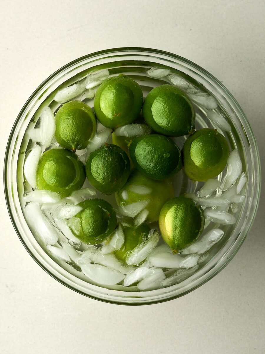 Green limes in an ice bath.