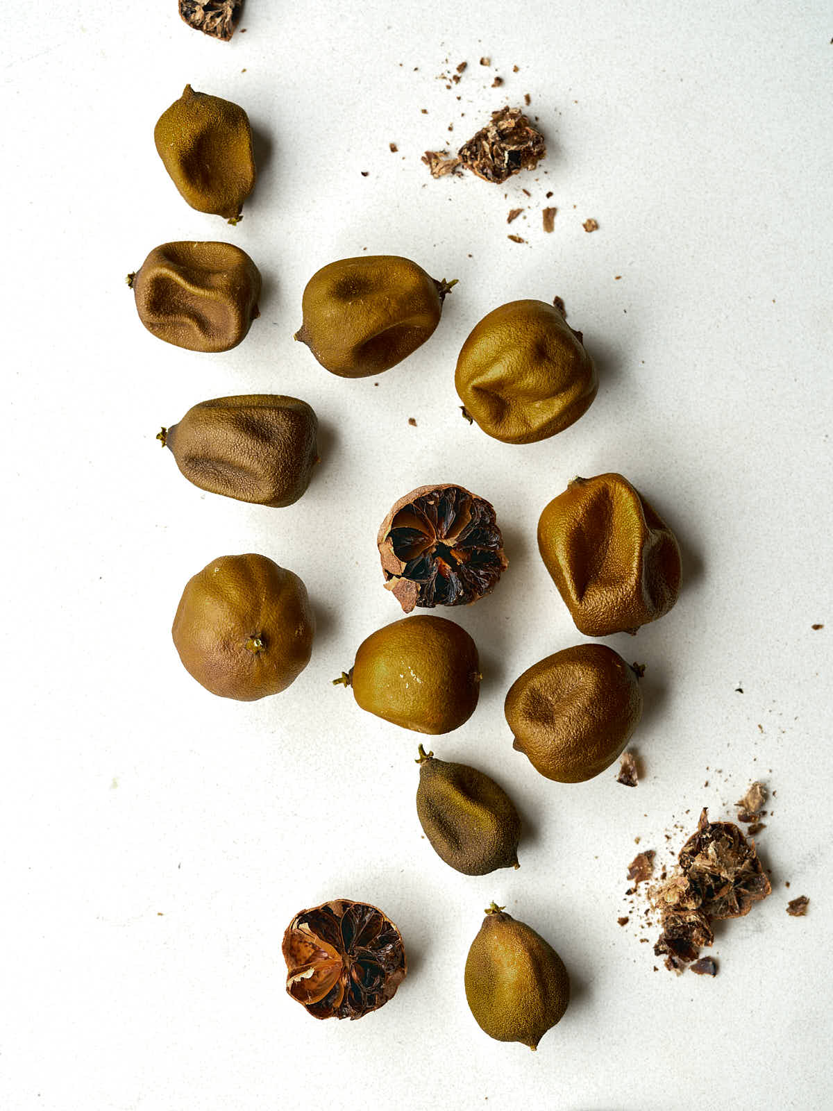 Whole and cracked dried limes on a countertop.