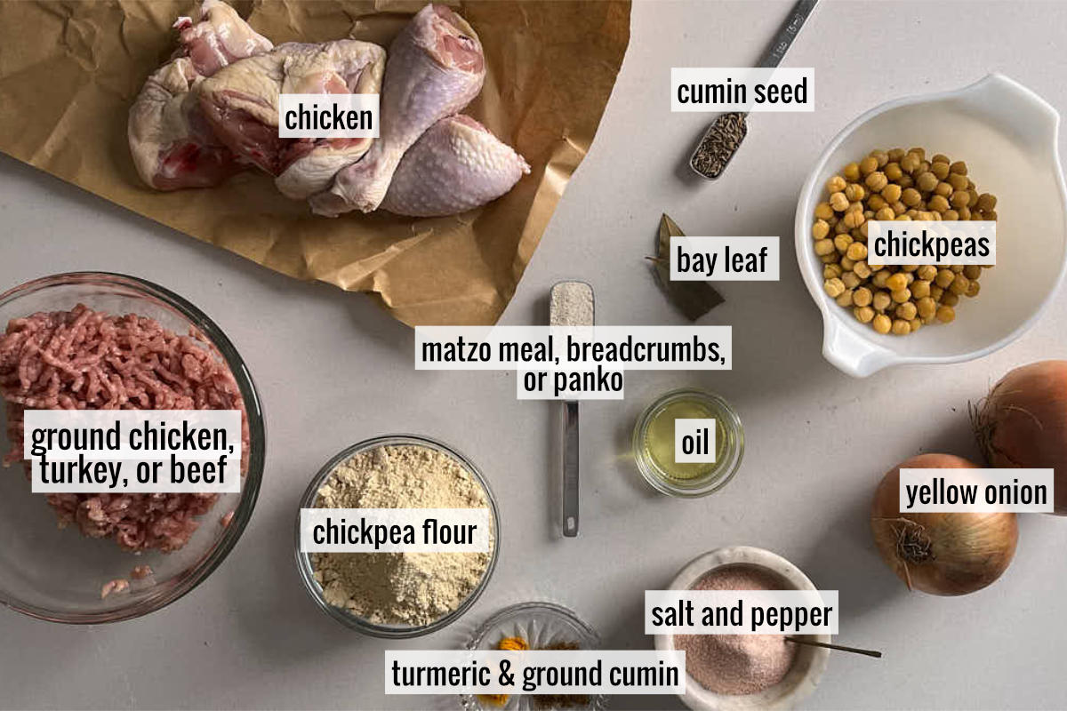 Chicken, chickpeas, and other ingredients for gondi laid out on a marble countertop.