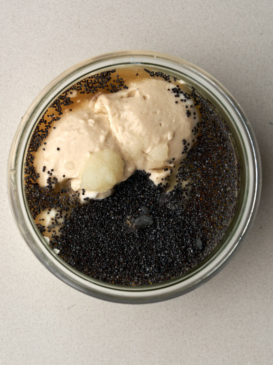 Poppy seeds, yogurt, and other ingredients in a glass jar.