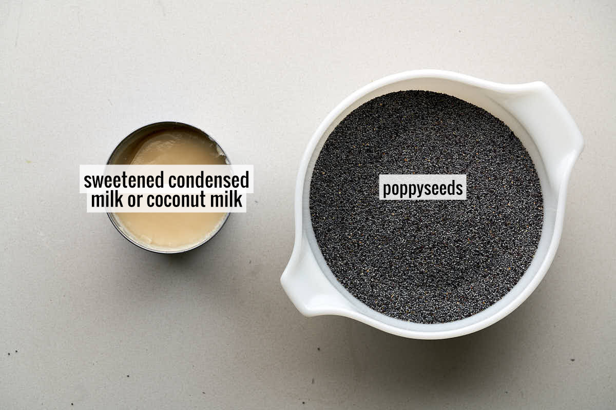 Poppyseeds in a white bowl next to a can of sweetened condensed milk.