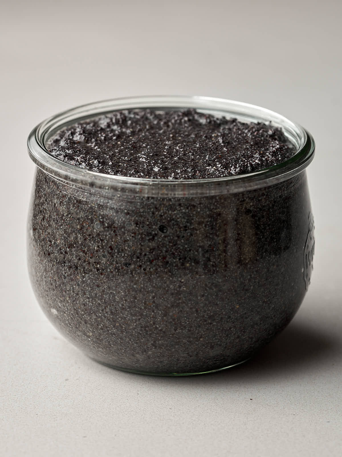 Front view of poppyseed filling in a glass jar.