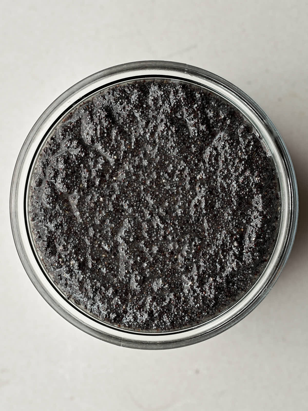 Top view of poppyseed filling in a glass jar.