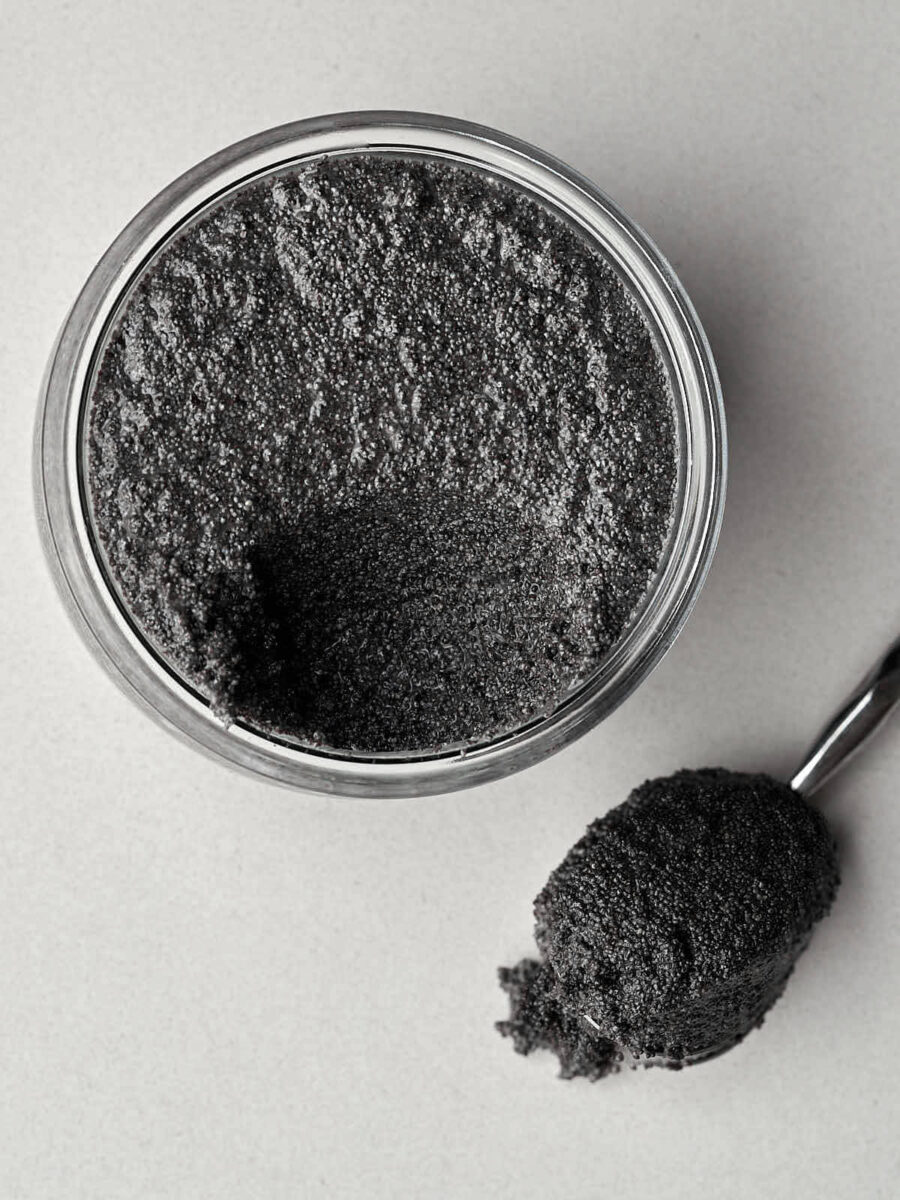 Poppyseed filling in a glass jar next to a spoon of poppyseed filling.